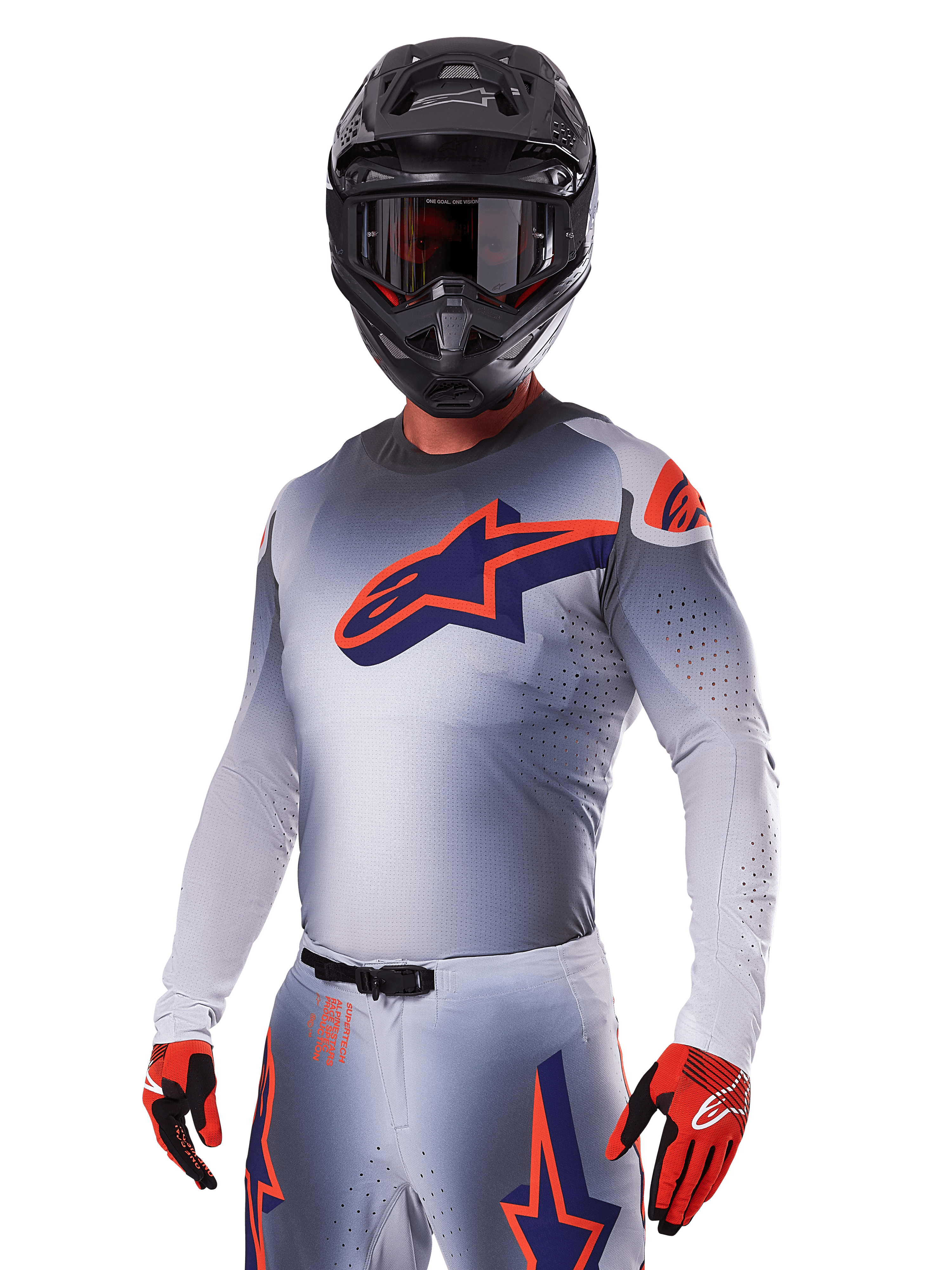 Motocross rider wearing Alpinestars 2025 Supertech Lipan Gear Set, Gray jersey and pants with navy and orange accents, matte black helmet with goggles, and red and black gloves, athletic performance gear for off-road racing