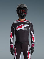 Jersey Alpinestars Supertech AFD Vista 2026, jersey de motocross en negro, rojo y blanco, mostrado en un piloto con casco negro, gafas y guantes, con un logotipo grande en el pecho y la marca 'SUPERTECH AFD', equipamiento de carreras profesional para rendimiento off-road