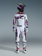 Motocross rider wearing complete 2026 Supertech AFD Vista Gear Set, White jersey and pants with purple, pink, and black accents, black helmet with purple branding and blue goggles, white boots with pink details, coordinated professional off-road racing outfit