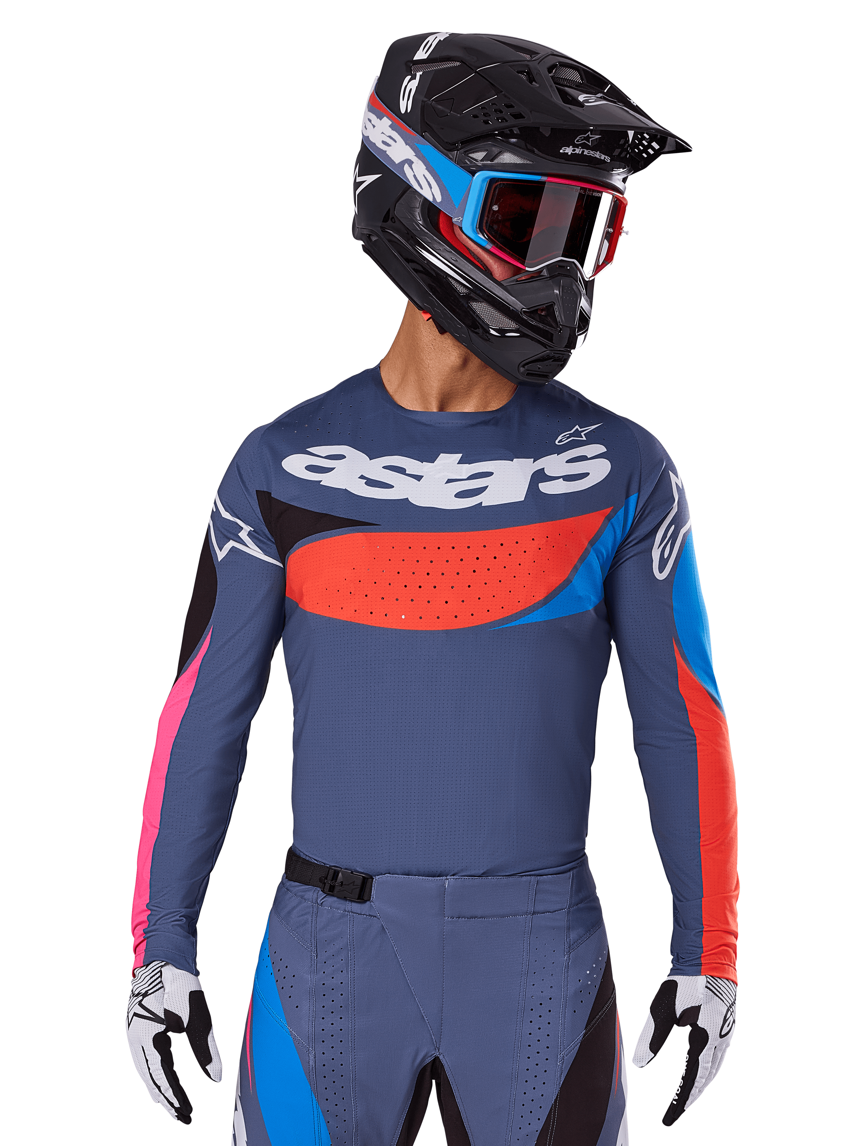 Alpinestars 2025 Techstar Dreem Jersey, jersey de motocross, gris con detalles en azul, rojo y rosa, con perforaciones cortadas por láser y un logotipo grande en el pecho, usado con pantalones a juego y casco de carreras negro