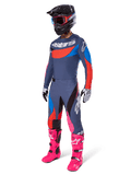 Alpinestars 2025 Techstar Dreem Motocross Gear Set, conjunto completo de equipamiento para carreras off-road con jersey gris y azul con detalles rojos, pantalones a juego con toques en rosa, casco negro, botas rosa brillante y guantes blancos y negros
