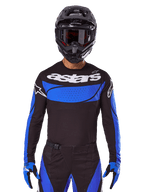 Alpinestars conjunto Techstar Dreem 2025 y jersey Techstar Dreem 2025, equipo de motocross negro y azul, usado por un piloto.