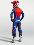 Alpinestars Jersey Racer Hunt, jersey de motocross para hombre, azul y rojo, de politejido transpirable que absorbe la humedad, vista trasera en modelo con equipo completo de protección off-road