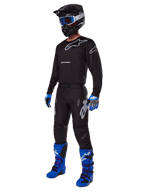 Alpinestars 2025 Racer Graphite Gear Set, equipo completo de motocross, camiseta y pantalones negros y grises con logotipos plateados, casco negro con gafas de lente azul, guantes azules y negros, botas azul brillante, equipo profesional de carreras todoterreno