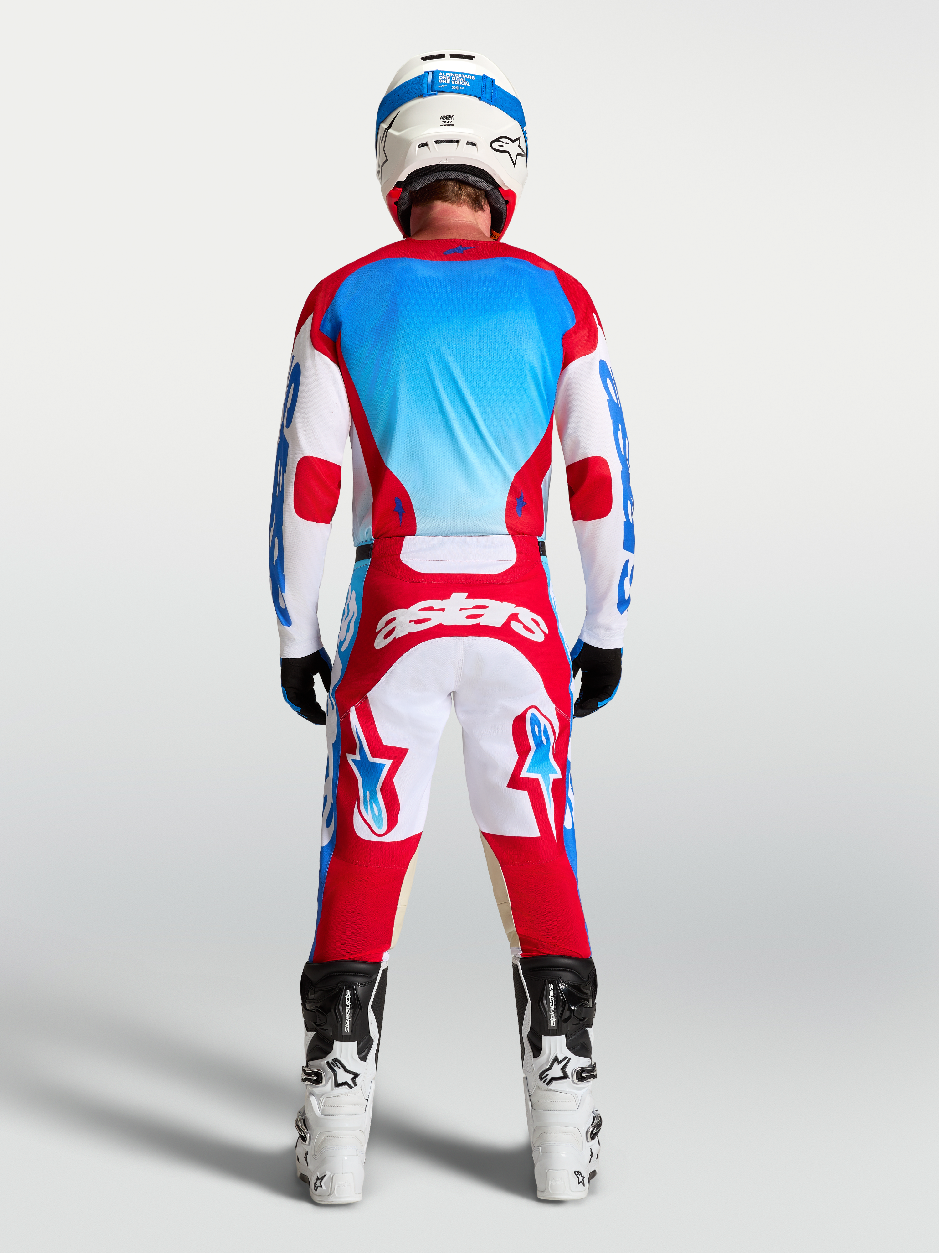 Alpinestars Pantalones Racer Hunt y Racer Hunt Gear Set, equipo de motocross rojo, blanco y azul, vista trasera en modelo con casco y botas