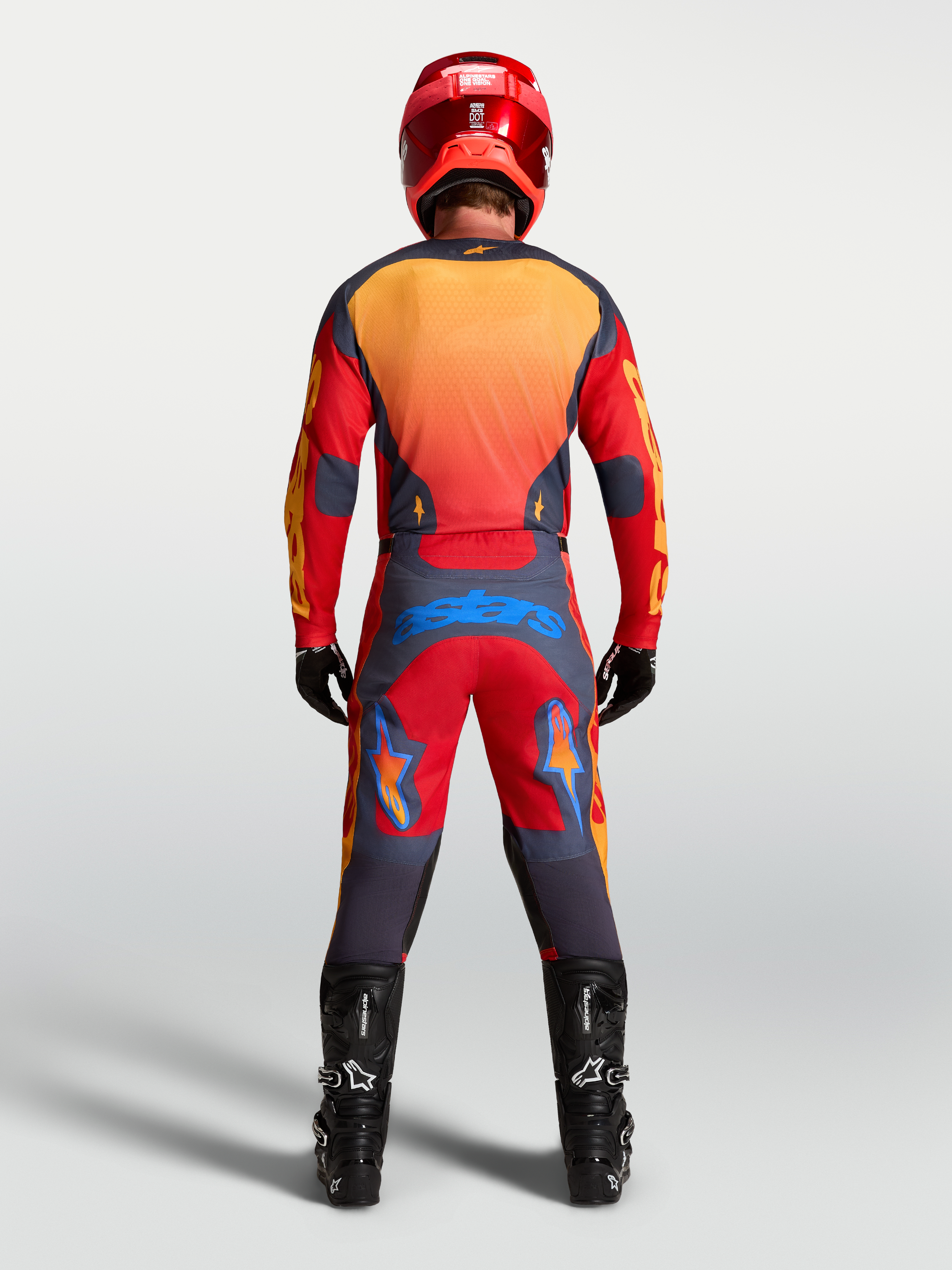 Jersey Racer Hunt de Alpinestars, equipo de motocross para hombre, rojo y gris, tejido técnico que absorbe la humedad, vista trasera del piloto equipado con casco y botas MX