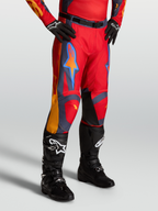 Alpinestars Racer Hunt, pantalones de motocross para hombre, rojos con detalles en gris y coral, usados con botas negras