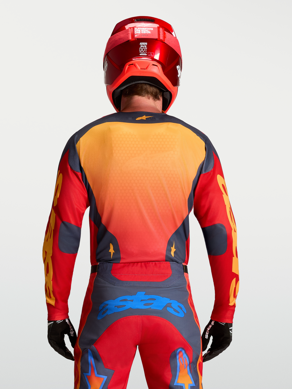 Alpinestars Racer Hunt Jersey, jersey de motocross para hombre, diseño rojo y gris con detalles amarillos y azules, vista trasera sobre modelo