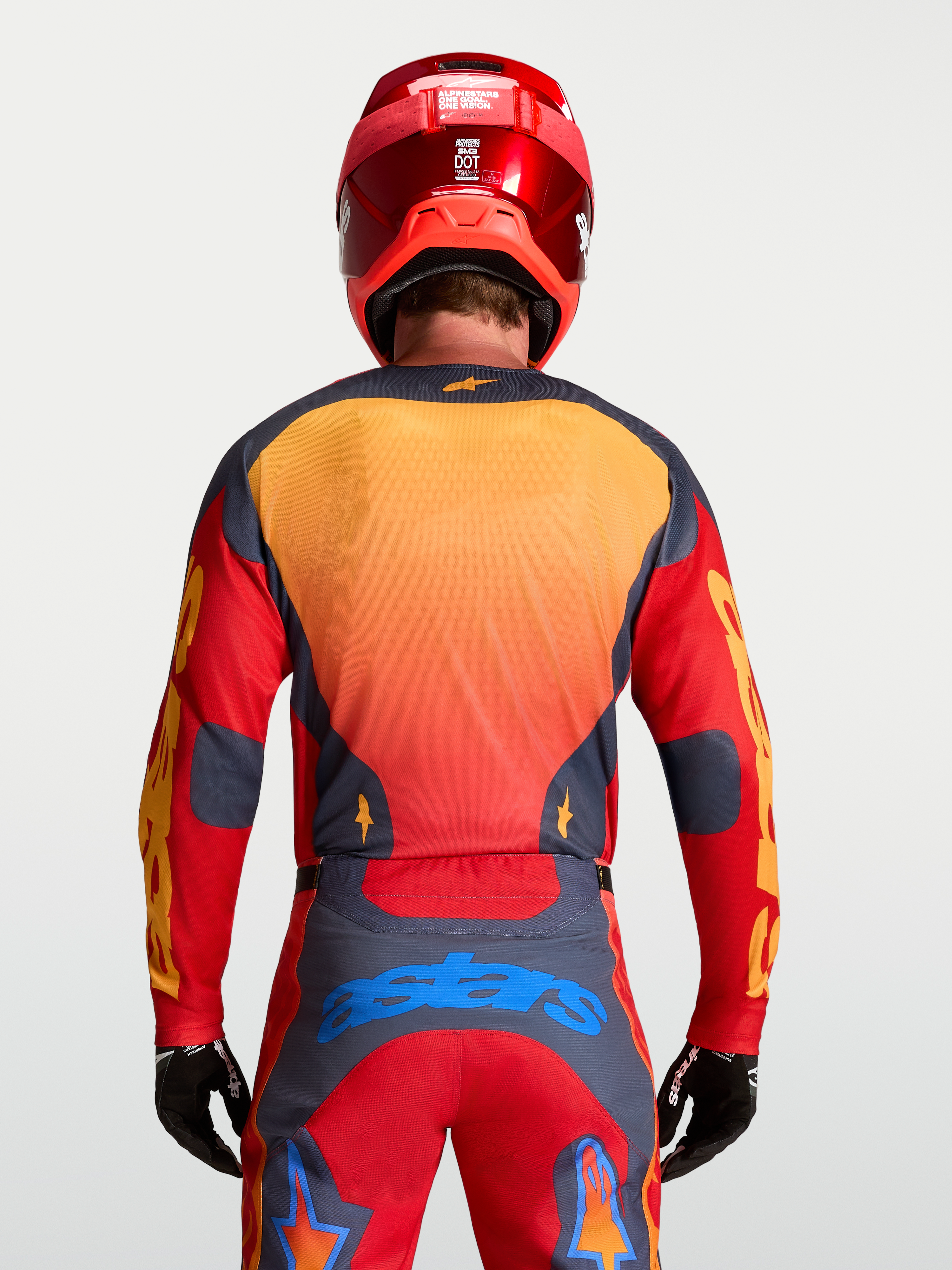 Alpinestars Racer Hunt Jersey, jersey de motocross para hombre, diseño rojo y gris con detalles amarillos y azules, vista trasera sobre modelo
