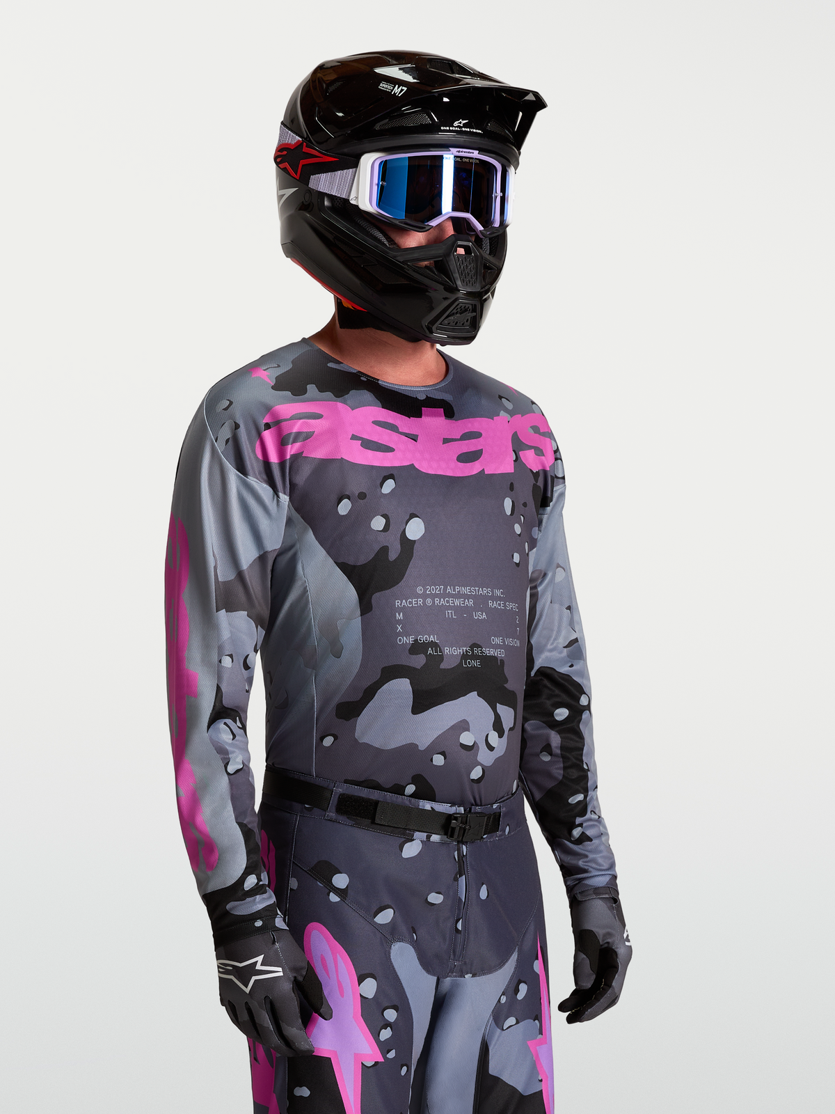 Alpinestars Jersey Racer Lone, jersey de motocross para hombre, gris camuflaje y morado, en modelo con casco y kit de MX.