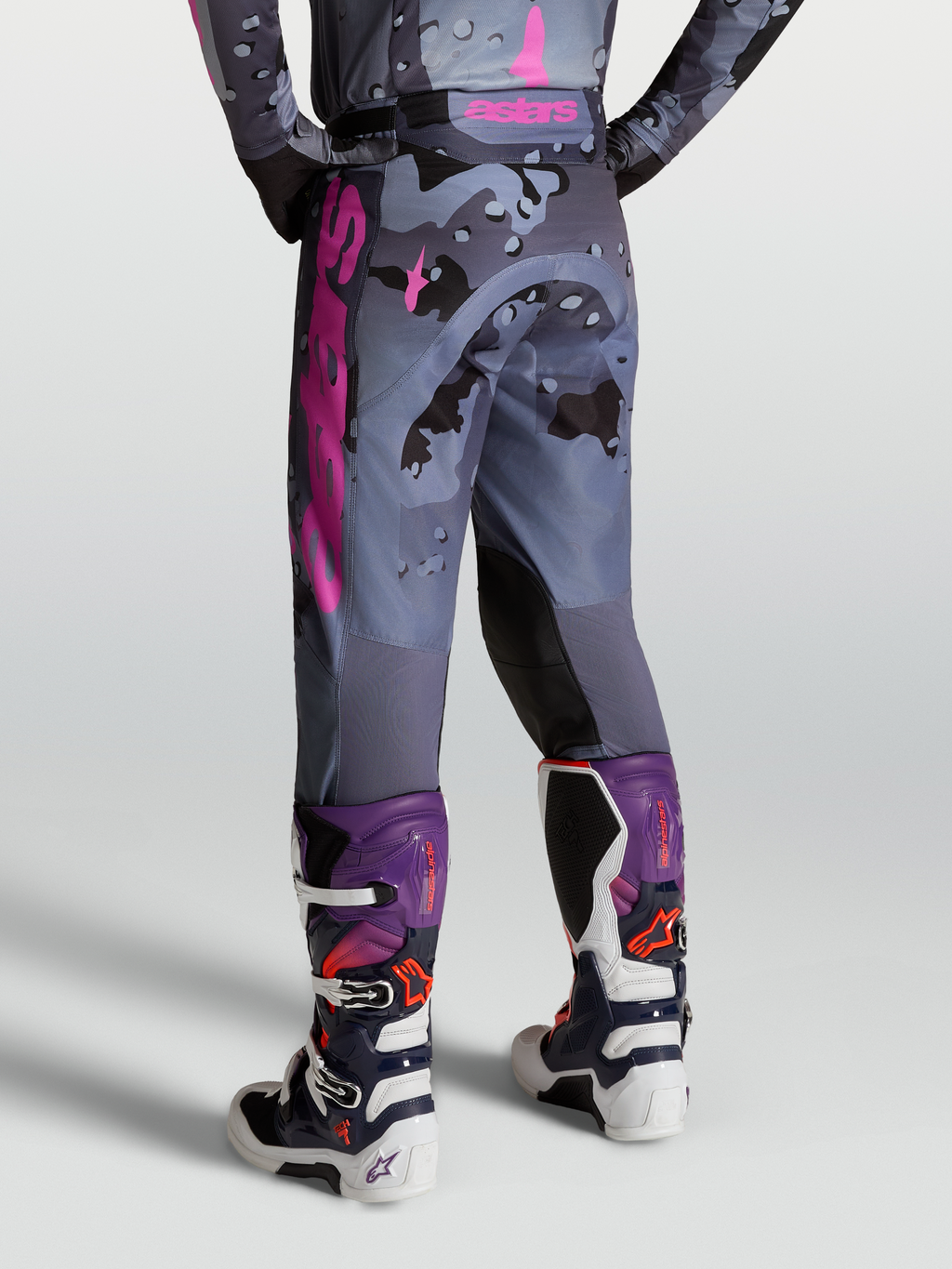Alpinestars Pantalones Racer Lone, pantalones de motocross para hombre, diseño camuflaje gris y morado, vista trasera con botas Tech 7, equipo off-road