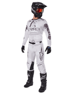 Alpinestars 2025 Racer Hollow Gear Set, traje de motocross, blanco y gris, jersey y pantalones con marca 'STARS' destacada, casco negro con gafas de lente tintada naranja-roja, guantes negros y botas negras, equipo profesional completo para motocross