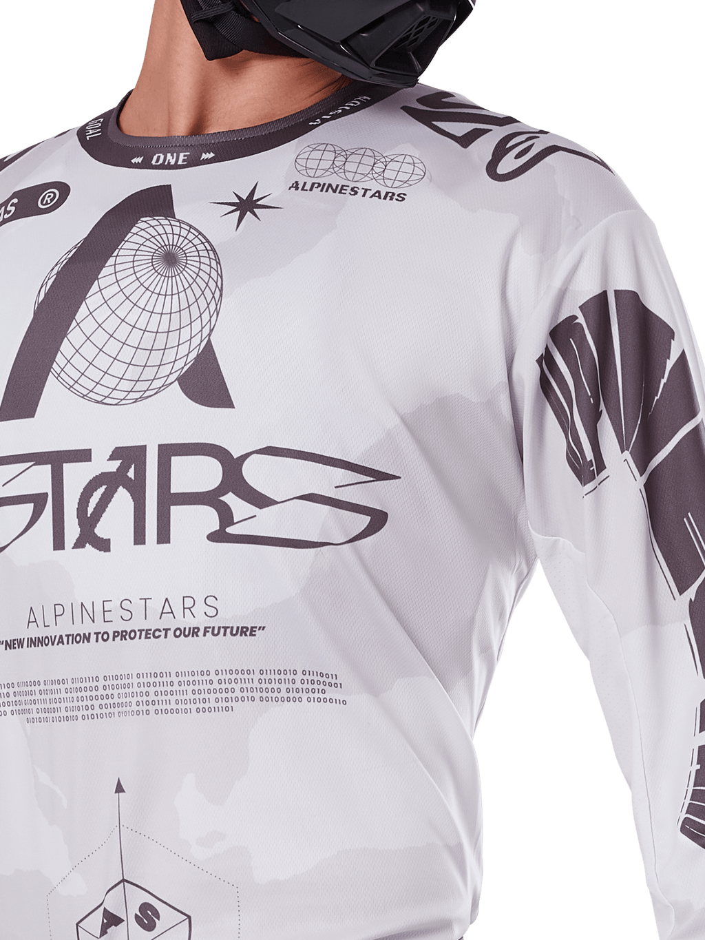 Primer plano del jersey Alpinestars Racer Hollow 2025, blanco y gris, con estampados gráficos negros con el logotipo del globo y código binario, ropa técnica de motocross para conducción off-road