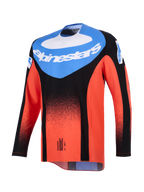 Alpinestars 2026 Techstar Knif Jersey, jersey de motocross, naranja, negro y azul UCLA, vista frontal con un panel azul en el pecho, logotipo blanco de Alpinestars y un degradado de puntos negros en las mangas y el cuerpo naranja, equipamiento de alto rendimiento para carreras todoterreno.