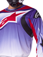 Alpinestars 2025 Fluid Wurx Jersey, jersey de motocross, púrpura y rojo brillante, primer plano de un piloto con el jersey y un gran logotipo de estrella de Alpinestars rojo en el pecho, detalles gráficos curvos en negro y rojo, ajuste atlético para carreras todoterreno