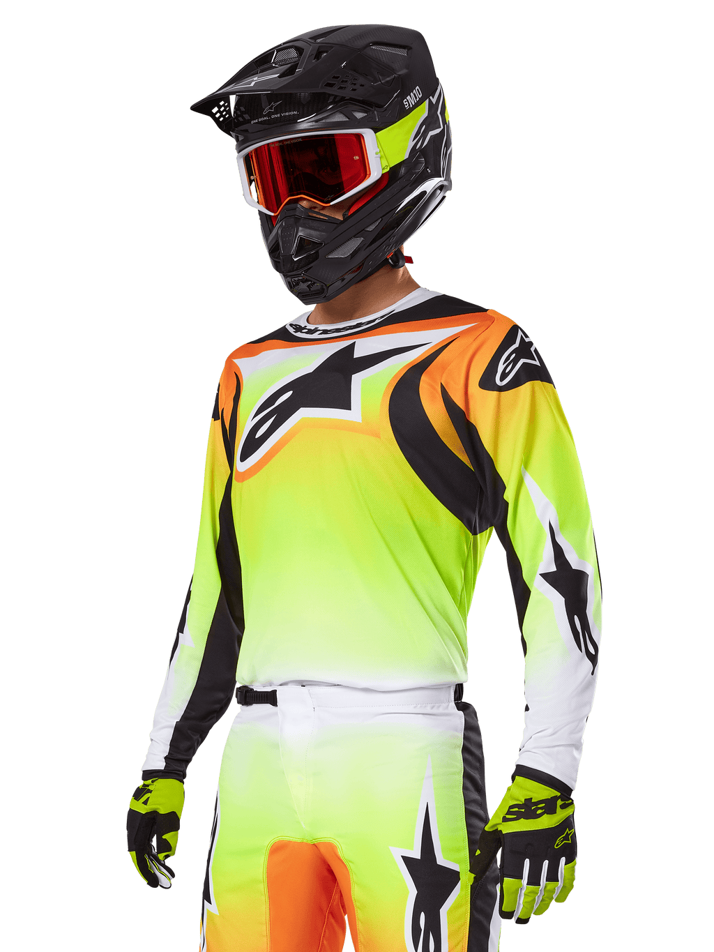 Piloto de motocross con el conjunto de equipamiento Alpinestars 2025 Fluid Wurx, jersey con degradado en amarillo y naranja con detalles negros y grandes logotipos de estrella, pantalones de motocross a juego, casco integral negro con gafas de lente roja y guantes amarillos, atuendo coordinado de alto rendimiento para carreras off-road