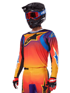 Alpinestars 2025 Fluid Wurx Gear Set, conjunto de equipo de motocross, degradado naranja, púrpura y azul, con un gran logotipo negro de A-stars, usado con casco negro y gafas azules, conjunto coordinado para carreras profesionales todoterreno