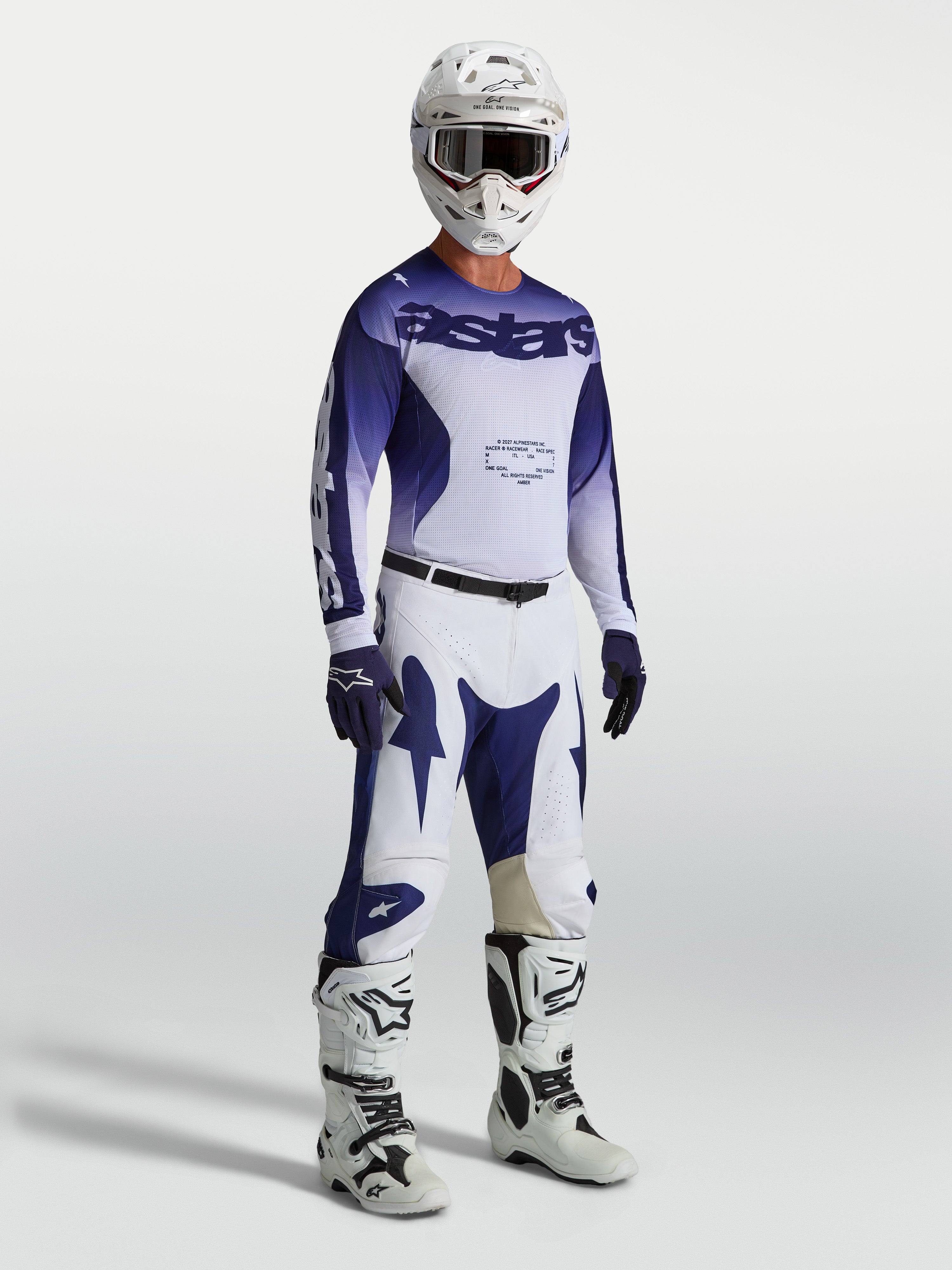 Alpinestars Racer Air Amber Jersey y conjunto de motocross para hombre, azul y blanco, equipo ventilado mostrado en modelo.