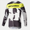 Alpinestars 2023 Racer Tactical Jersey, jersey de motocross, camuflaje gris y amarillo flúor, con un patrón de camuflaje gris y negro con un panel amarillo brillante en el pecho y el logotipo de Alpinestars, equipamiento de alto rendimiento de manga larga para carreras off-road