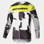 Alpinestars 2023 Racer Tactical Jersey, jersey de motocross, camuflaje gris y amarillo flúor, con un patrón de camuflaje gris y negro con un panel amarillo brillante en el pecho y el logotipo de Alpinestars, equipamiento de alto rendimiento de manga larga para carreras off-road