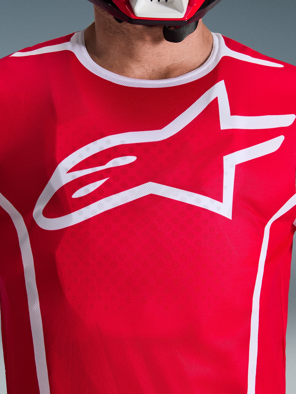 Alpinestars 2026 Fluid Apex Jersey, Red and White, close-up view of chest with large white Astars logo, white sport collar, and moisture-wicking fabric for motocross performance