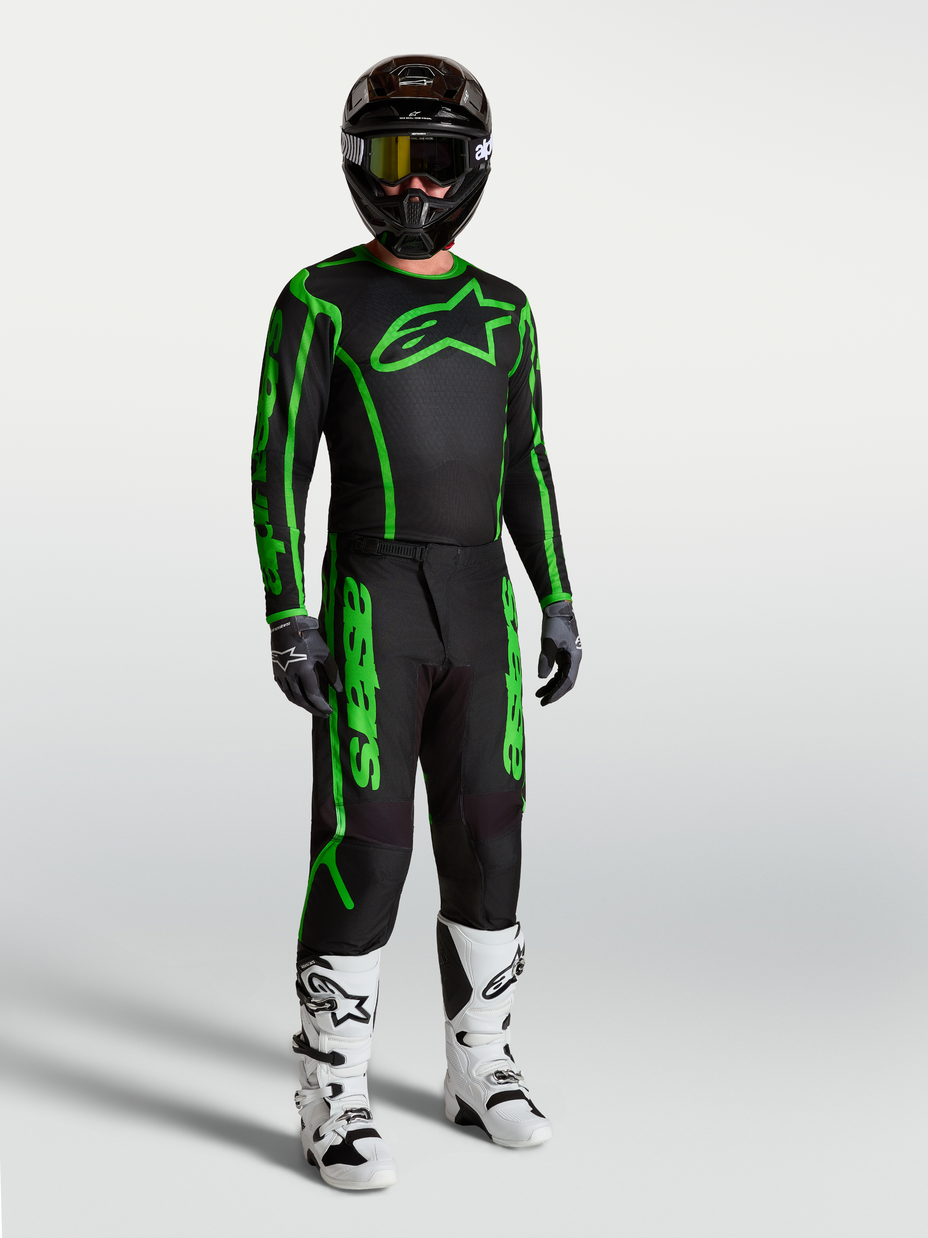 Alpinestars jersey Fluid Apex V2 negro y verde flúor para motocross de hombre, mostrado con pantalones y botas.