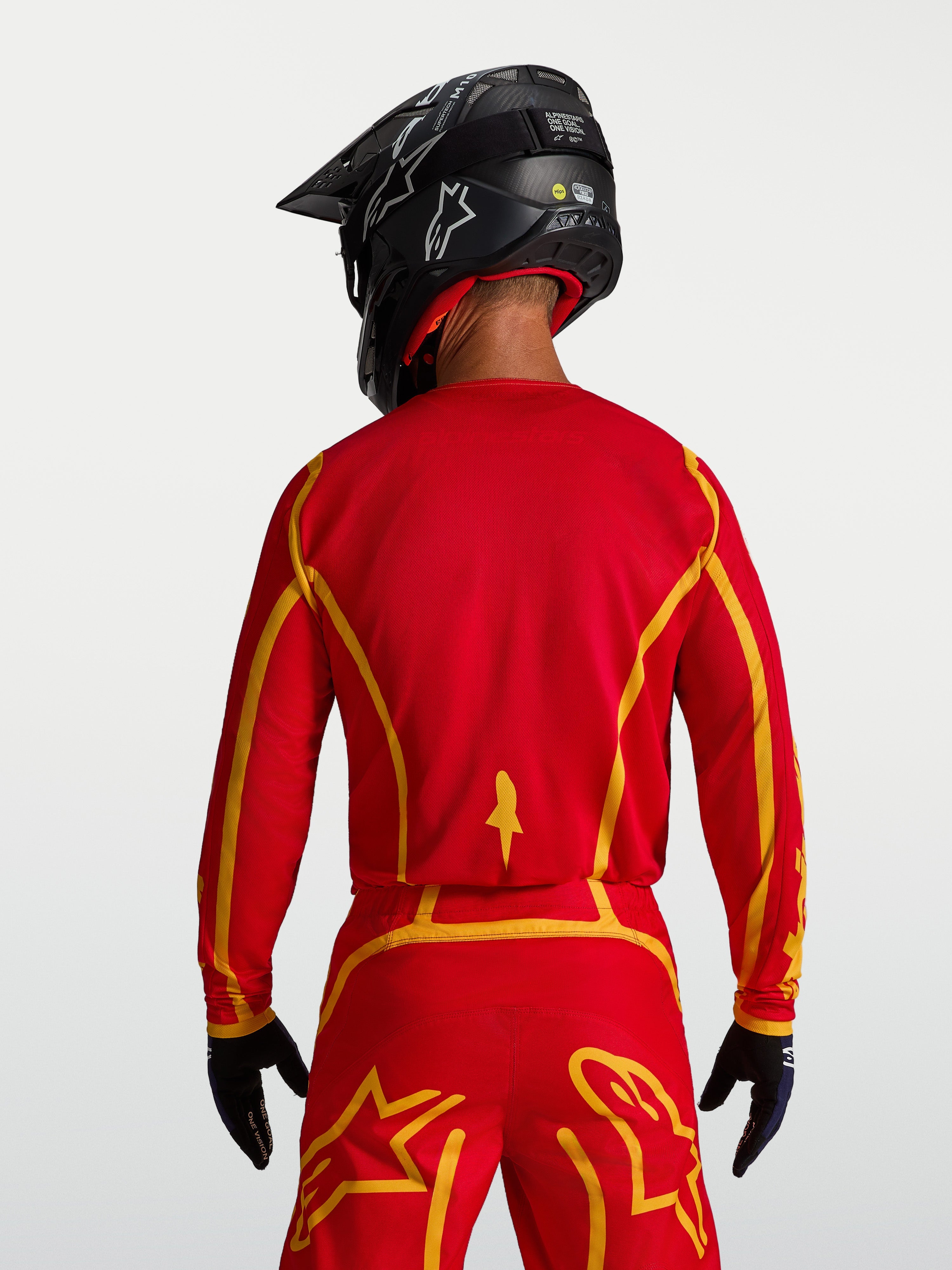 Jersey Fluid Apex V2 de Alpinestars, equipo de motocross para hombre, vista trasera en rojo y dorado, corte ergonómico y tejido transpirable