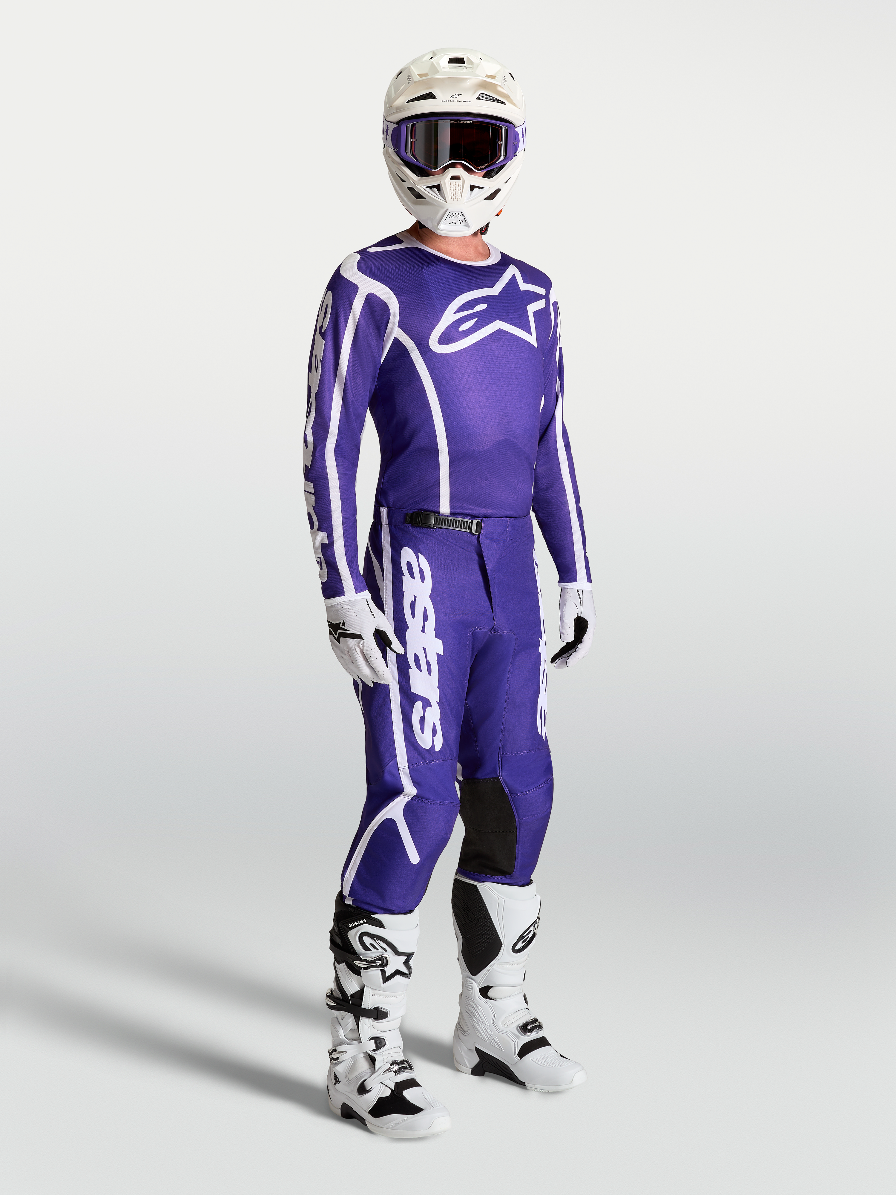 Jersey Alpinestars Fluid Apex V2 y pantalones a juego, conjunto de motocross para hombre en azul profundo y blanco, con casco y botas blancas, equipación técnica para pilotaje off-road