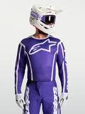 Alpinestars Fluid Apex V2 Jersey, jersey de motocross para hombre, azul y blanco, con tejido transpirable de alto rendimiento y ajuste atlético ergonómico, mostrado con casco y guantes de MX