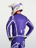 Alpinestars Jersey Fluid Apex V2, jersey de motocross para hombre, azul y blanco, construcción transpirable de polifabricado, usado por modelo con casco y guantes