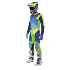 Alpinestars 2024 Racer Hoen Jersey, jersey de motocross, amarillo flúor y azul night navy, usado por un piloto con pantalones a juego, casco y botas blancas, equipamiento profesional para conducción fuera de carretera