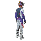 Alpinestars 2024 Racer Hoen Pants, pantalones de motocross en gris claro, azul y naranja, vista trasera del equipo completo con casco, jersey coordinado y botas blancas, diseño ergonómico para alto rendimiento.