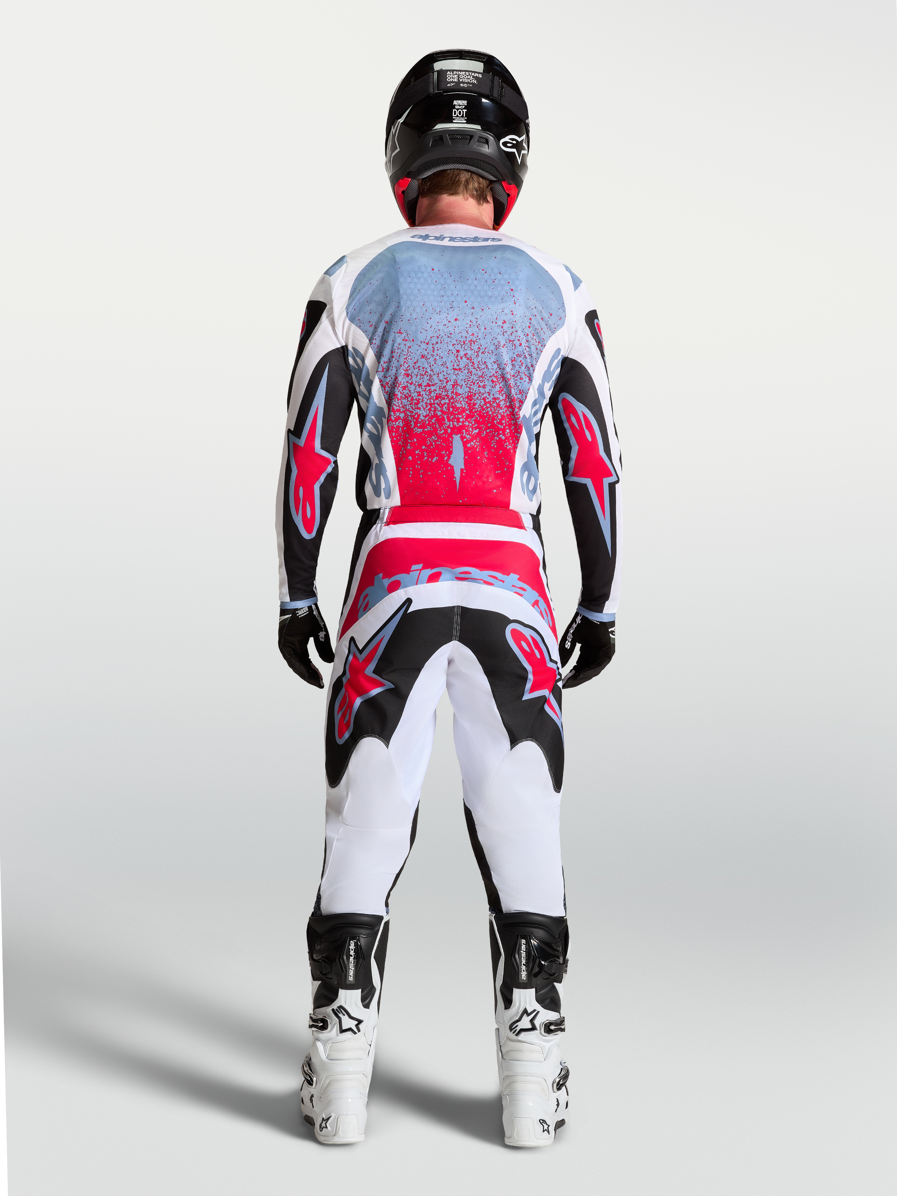 Alpinestars Jersey Fluid Drag, jersey de motocross para hombre, negro y rojo fluo, vista trasera de un piloto.