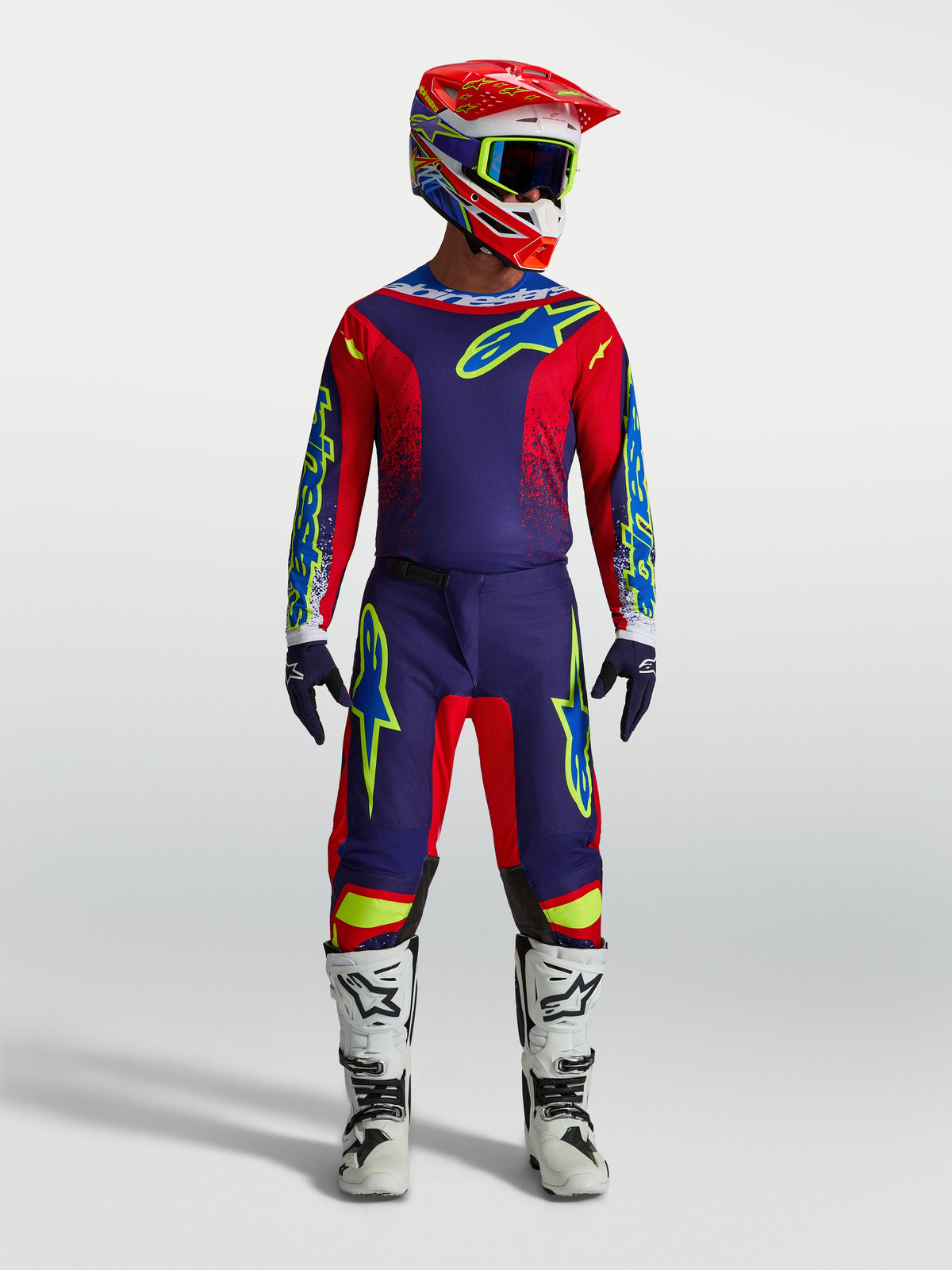 Alpinestars Jersey Fluid Drag y Fluid Drag Gear Set, conjunto de motocross para hombre en azul marino y rojo fuego con casco y botas blancas.