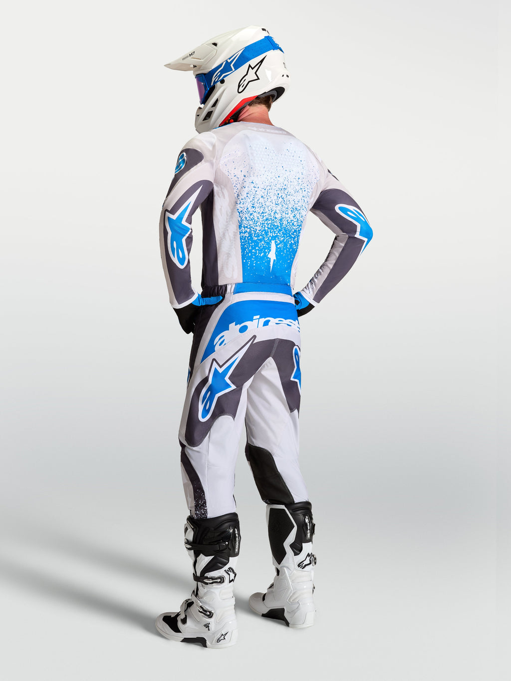 Alpinestars Fluid Drag Gear Set, conjunto de motocross para hombre con jersey y pantalones en gris y azul, vista trasera de equipamiento técnico MX de alto rendimiento