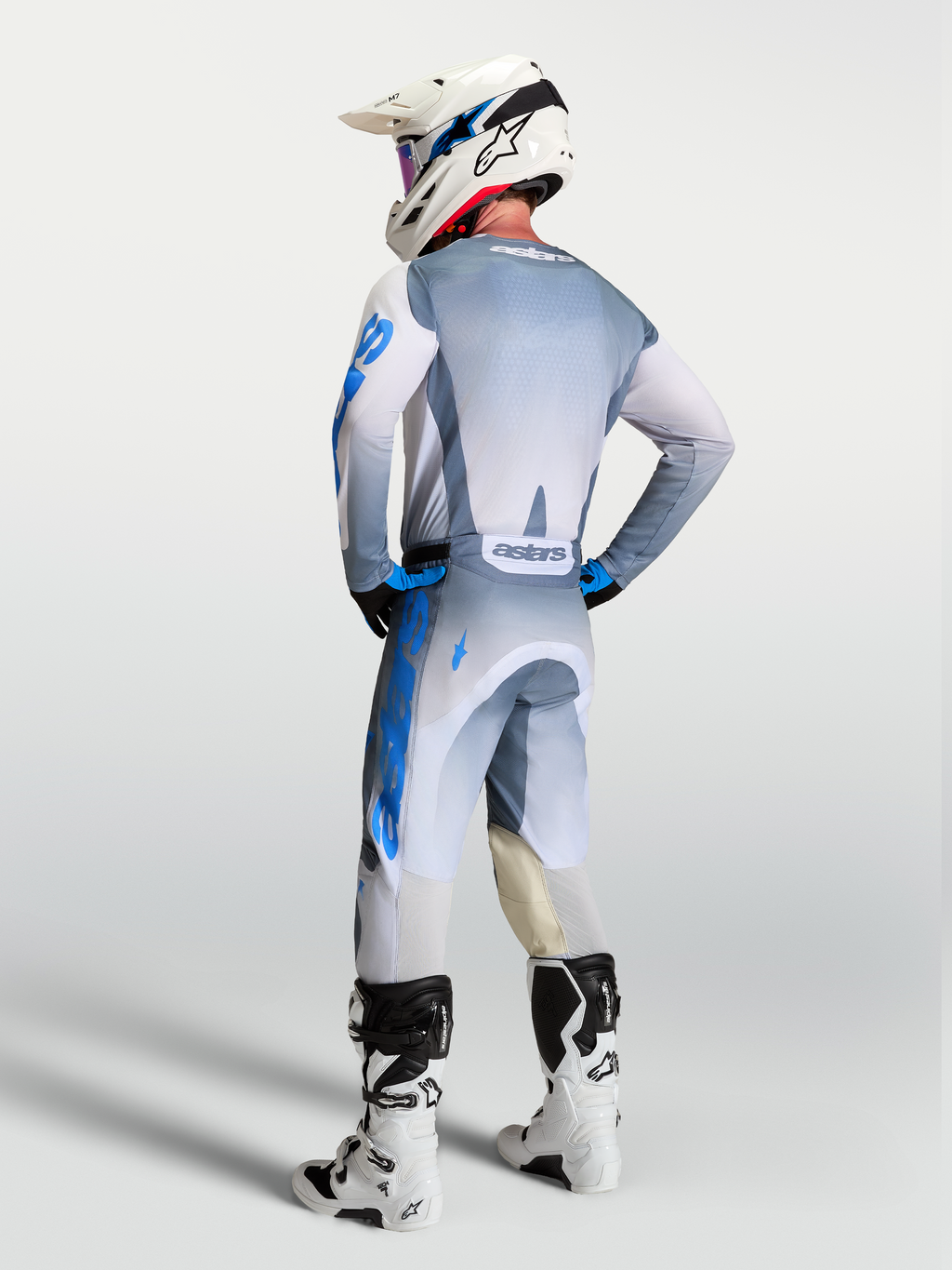 Alpinestars Racer Amber y Gear Set 2027, equipo de motocross todoterreno gris y azul, vista trasera en piloto