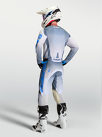 Alpinestars Racer Amber y Gear Set 2027, equipo de motocross todoterreno gris y azul, vista trasera en piloto