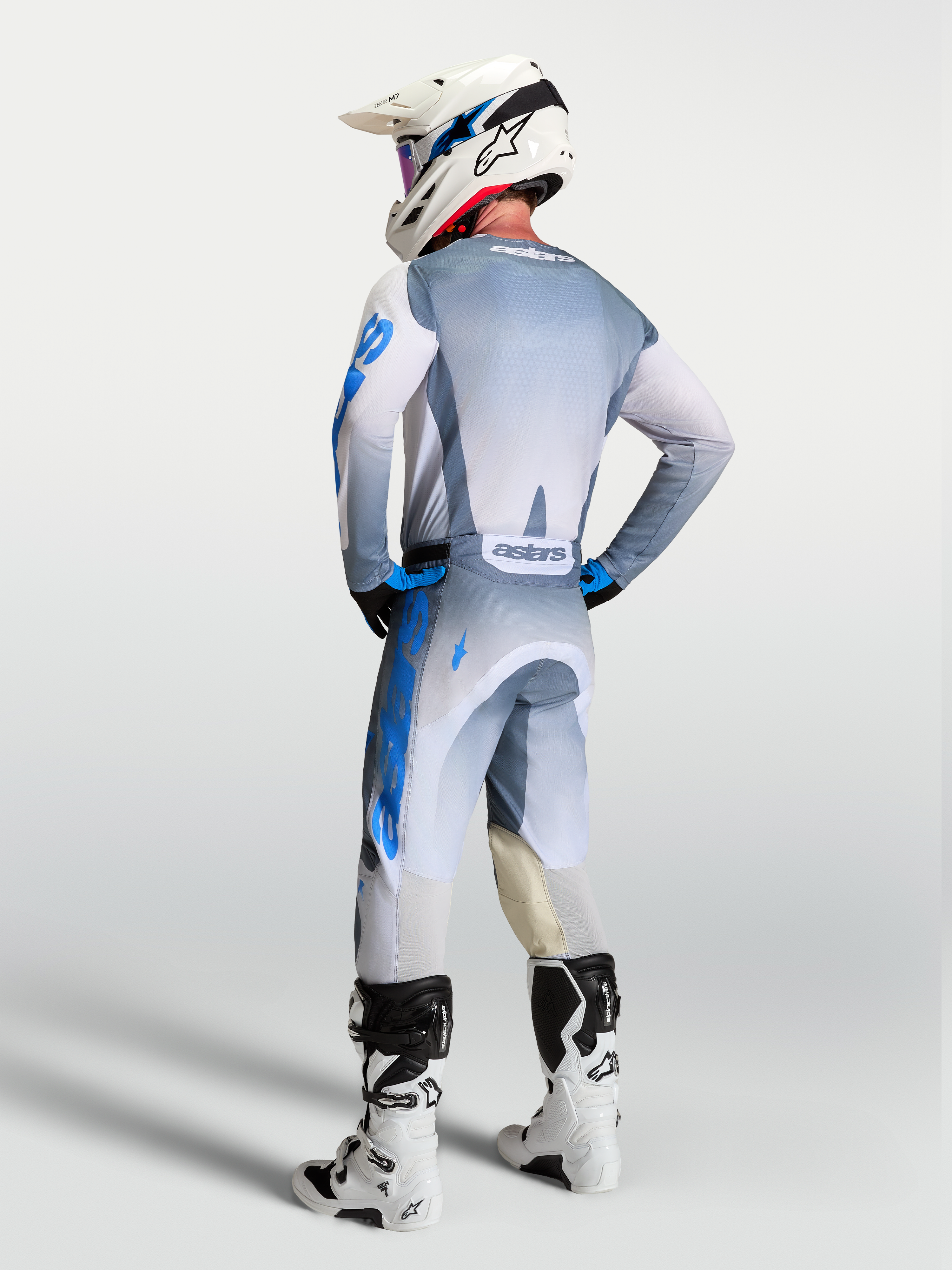 Alpinestars Racer Amber y Gear Set 2027, equipo de motocross todoterreno gris y azul, vista trasera en piloto
