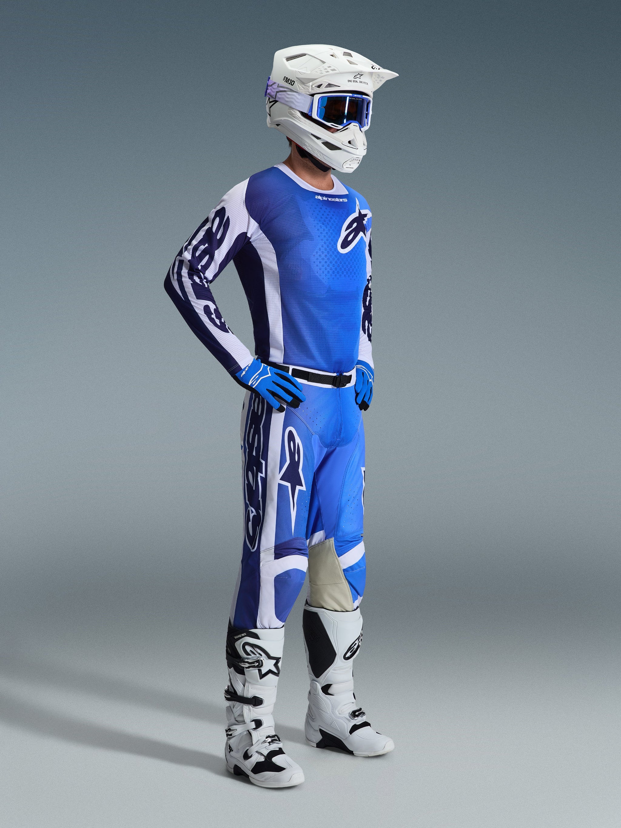 Motocross rider wearing the Alpinestars 2026 Racer Air Portl Jersey in Ucla Blue and White, paired with matching blue and white pants, white helmet, blue goggles, and white and black boots, full off-road racing kit