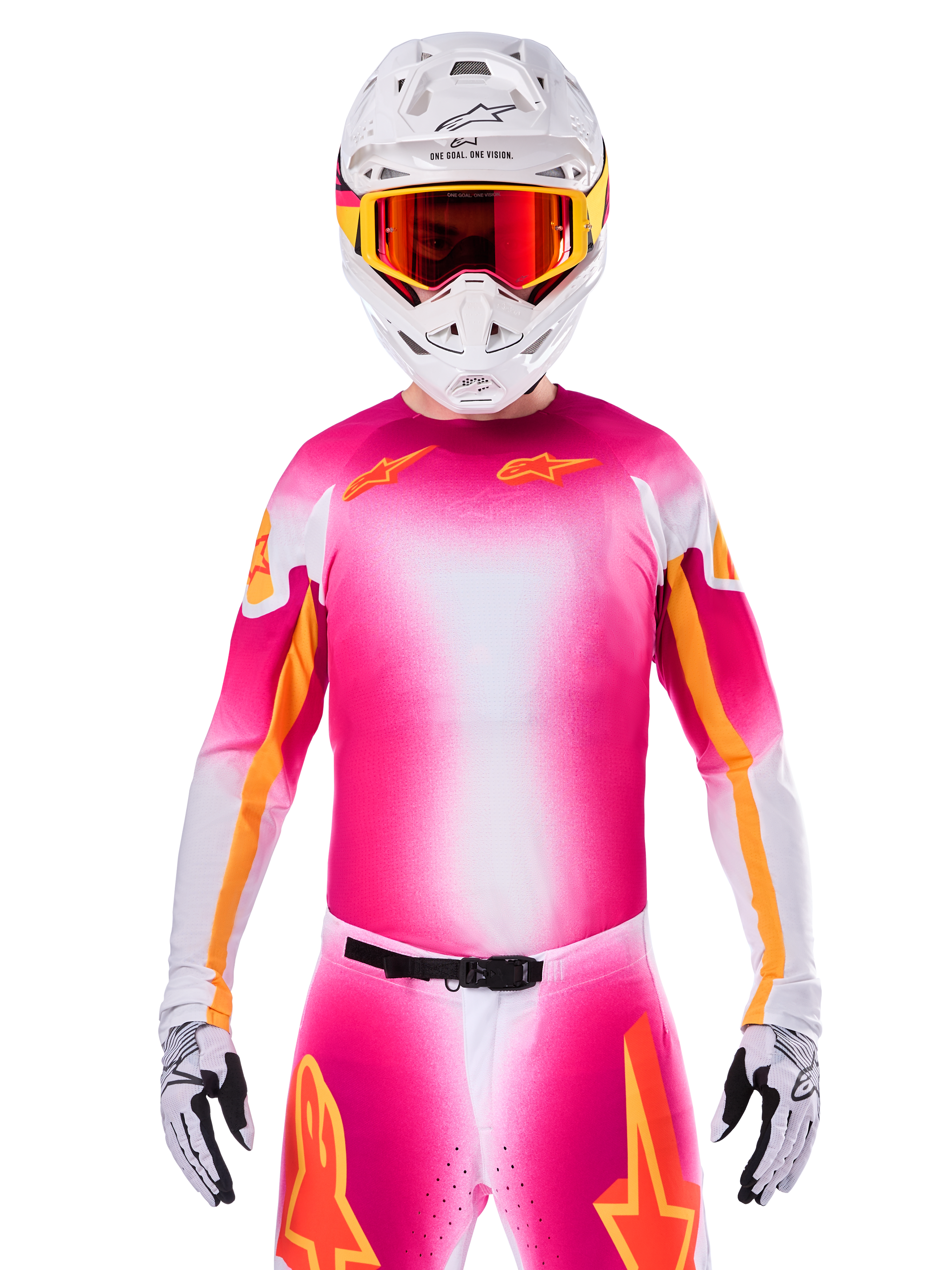Jersey Alpinestars Limited Edition Supertech AFD MIG, camiseta de motocross rosa flúor y blanco con un degradado vibrante y logotipos de estrellas naranjas, usada como un kit de carreras completo con pantalones a juego, casco blanco y gafas rojas, ropa profesional para conducción en tierra