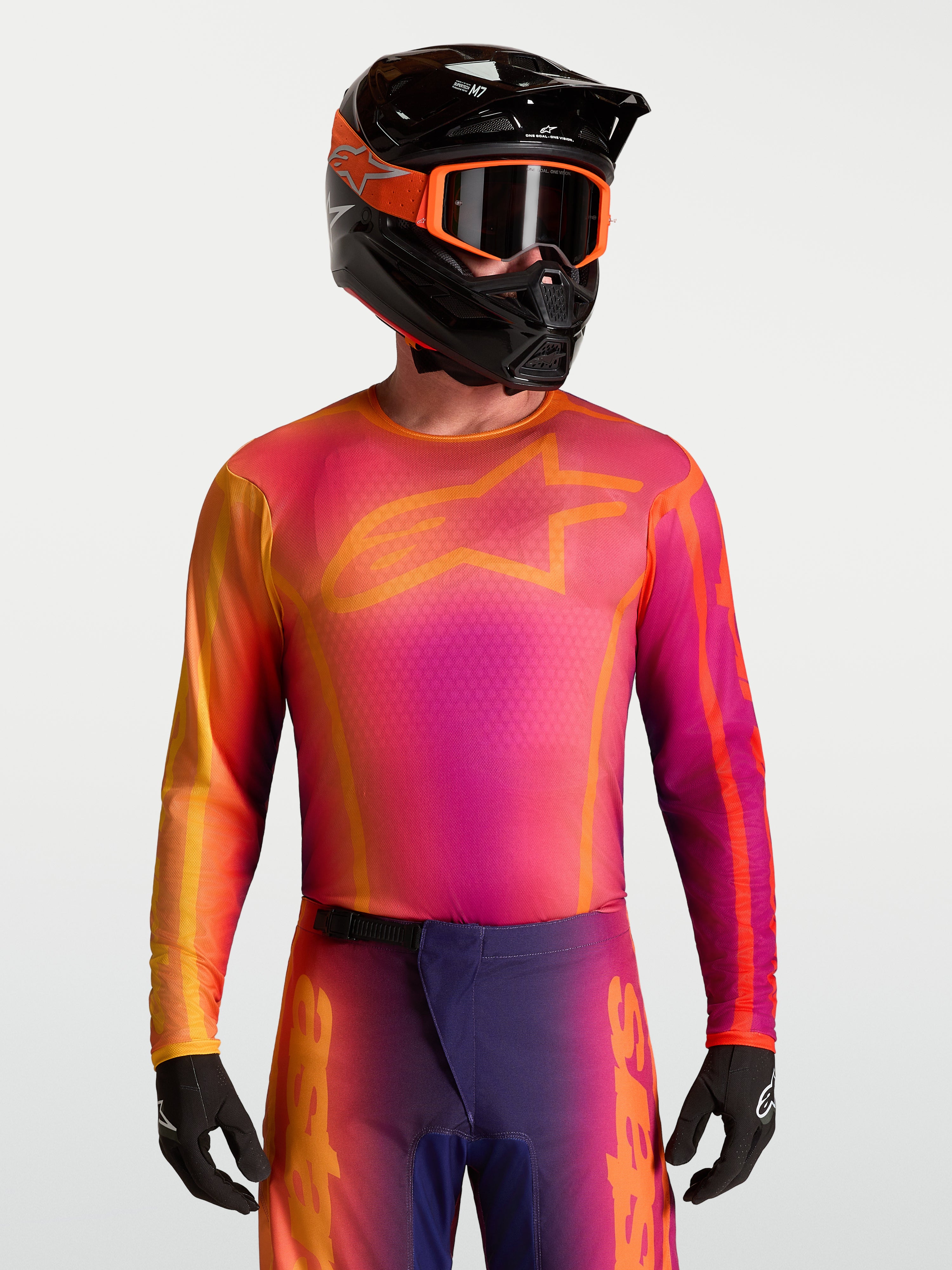 Alpinestars jersey Fluid Kepler, jersey de motocross para hombre, morado y naranja, tejido técnico transpirable para off-road, ajuste atlético, mostrado en un piloto con casco
