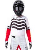 Piloto de motocross con equipamiento completo de competición, Jersey Techstar Deep Edición Limitada en blanco y negro con mangas rojas, con gráficos ondulados y el logotipo de Alpinestars destacado, pantalones de motocross blancos, casco y gafas negros, conjunto coordinado para carreras todoterreno