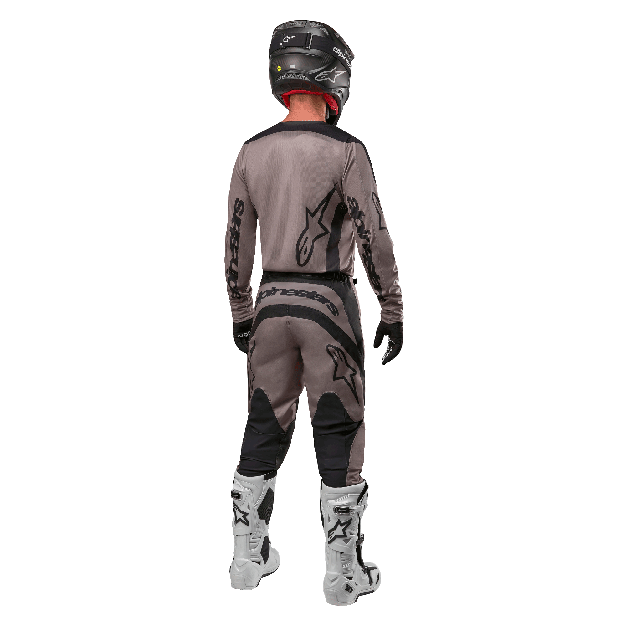 Alpinestars 2024 Fluid Lurv Jersey, jersey de motocross, Mud Black, vista trasera de un piloto de motocross con equipamiento de carreras a juego, casco negro y botas blancas, con logotipos negros de Alpinestars y un ajuste atlético para rendimiento todoterreno.