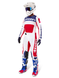 Conjunto Alpinestars Techstar Fortitude Edición Limitada, equipo de motocross, rojo, blanco y azul, con un jersey blanco con gráficos llamativos, pantalones de carrera a juego, casco blanco con gafas y botas coordinadas en azul y rojo, equipo de carreras profesional para rendimiento todoterreno