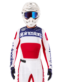 Alpinestars Limited Edition Techstar Fortitude Jersey, jersey de motocross para carreras, blanco, rojo y azul, usado con pantalones y casco a juego, con la marca Alpinestars y el lema One Goal One Vision, detalles perforados y diseño estilizado para rendimiento en todoterreno