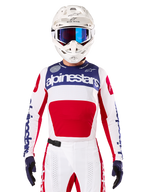 Alpinestars Limited Edition Techstar Fortitude Jersey, jersey de motocross para carreras, blanco, rojo y azul, usado con pantalones y casco a juego, con la marca Alpinestars y el lema One Goal One Vision, detalles perforados y diseño estilizado para rendimiento en todoterreno