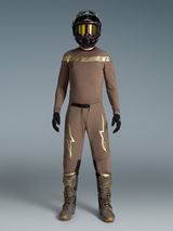 Conjunto Supertech Air Gold Edición Limitada, equipo de motocross marrón con logos dorados, botas y casco a juego.