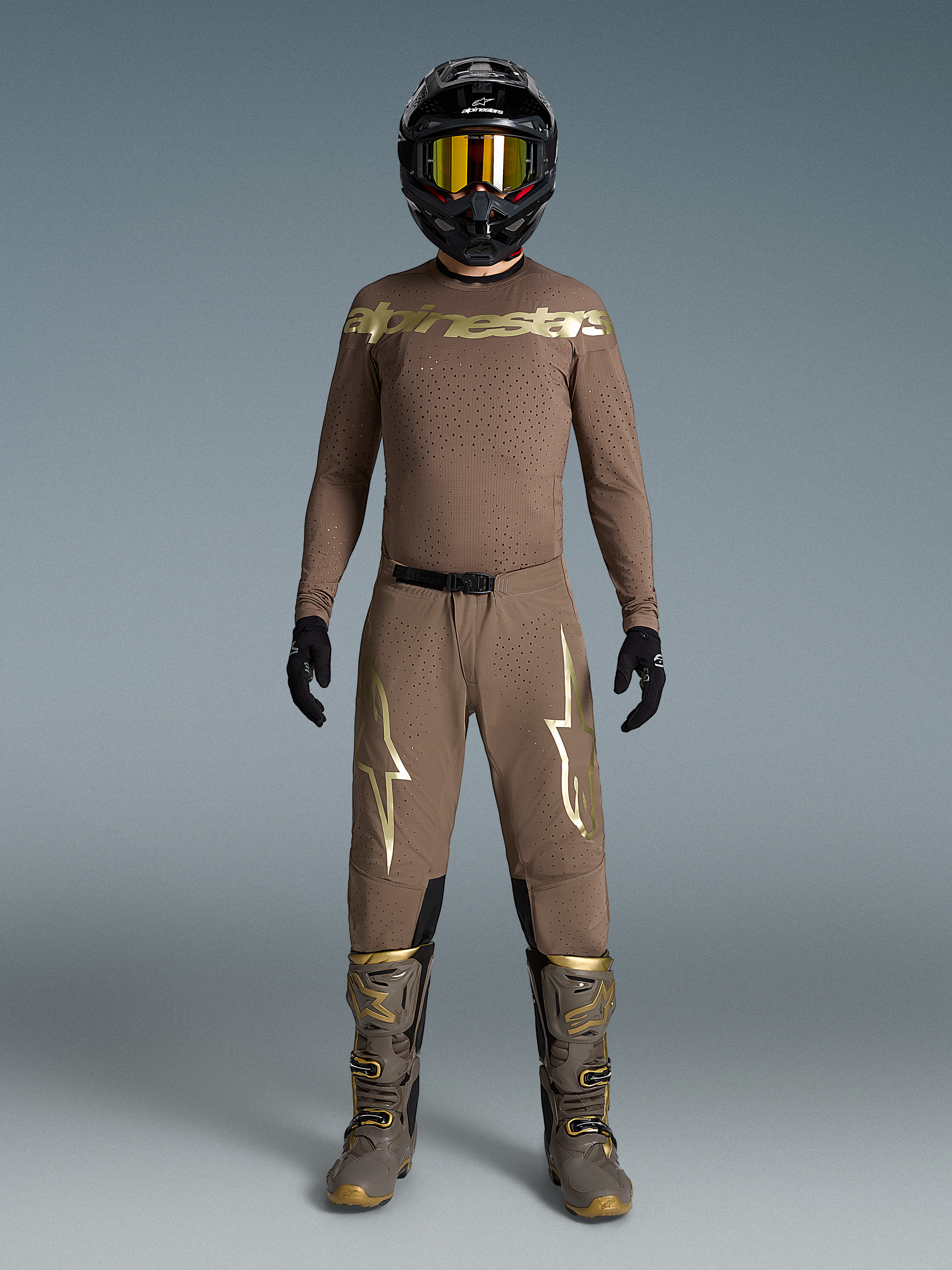 Conjunto Supertech Air Gold Edición Limitada, equipo de motocross marrón con logos dorados, botas y casco a juego.