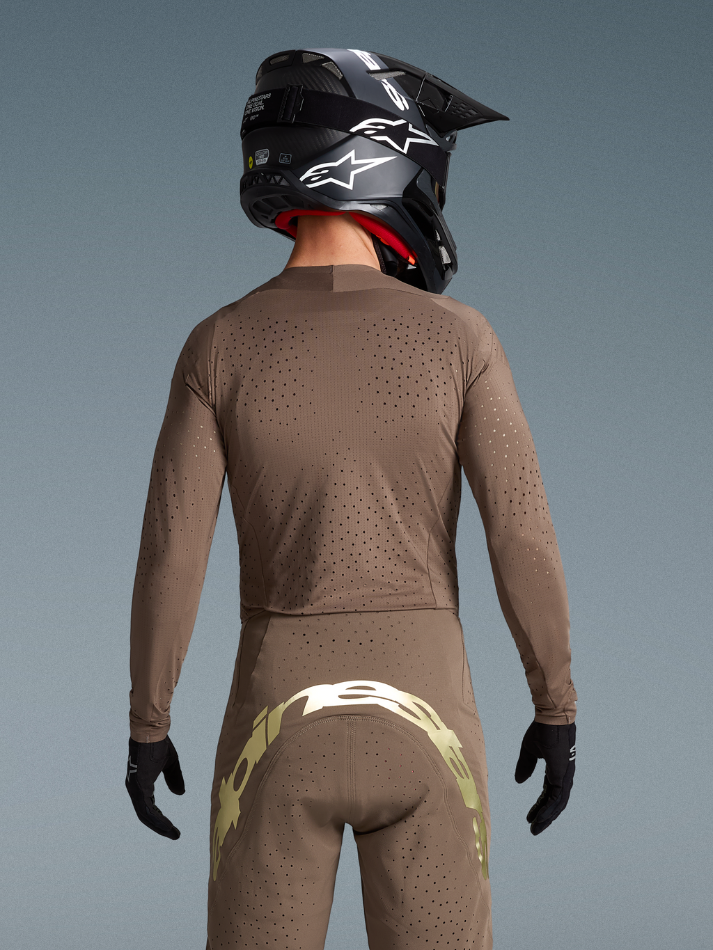 Alpinestars conjunto Supertech Air Gold Edición Limitada, equipamiento de motocross, marrón y dorado, ventilación cortada con láser, vista trasera con logotipo metálico