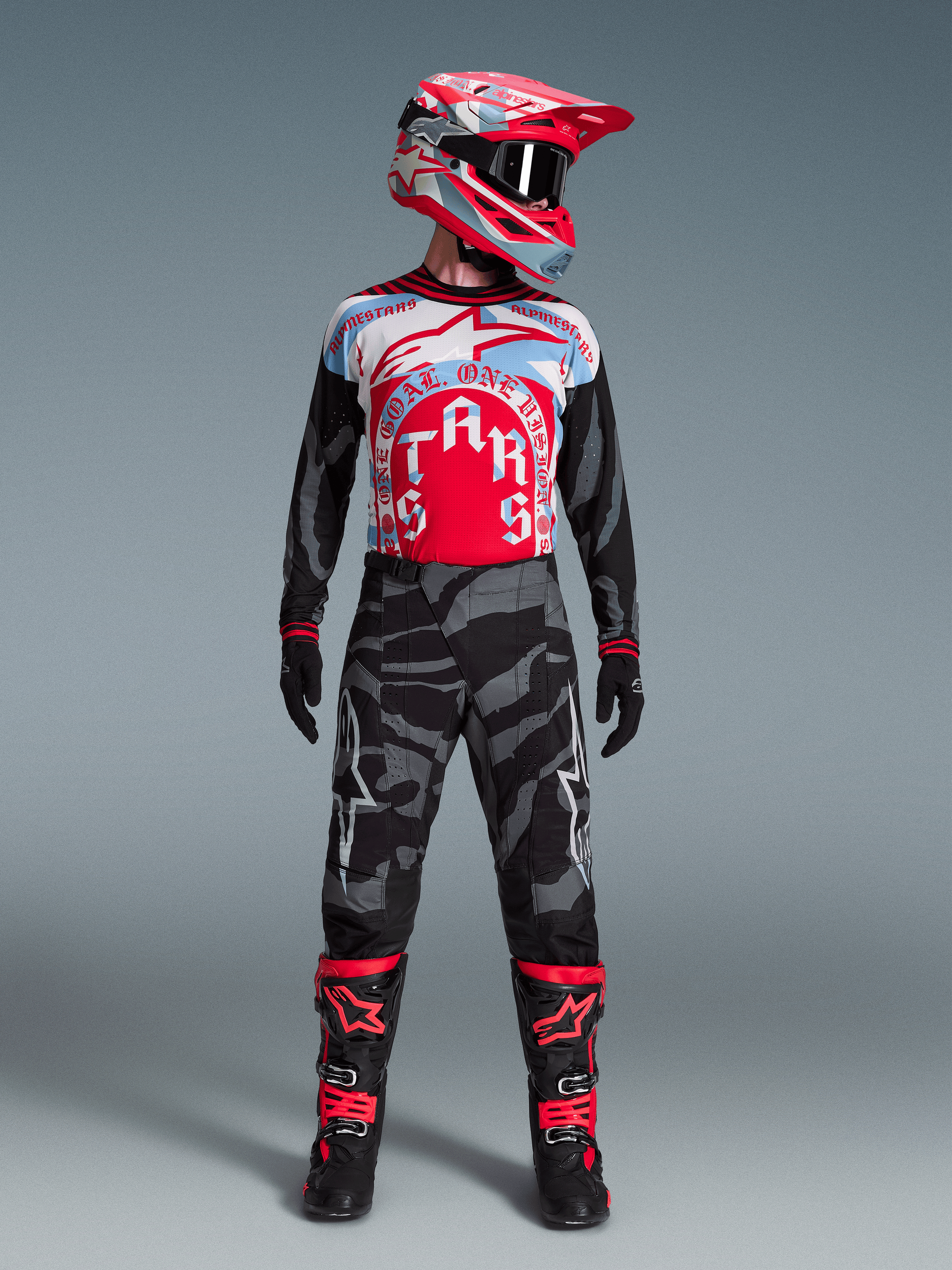 Conjunto Alpinestars Techstar Beast Coast Edición Limitada, jersey rojo y azul, pantalones de camuflaje y botas de motocross.